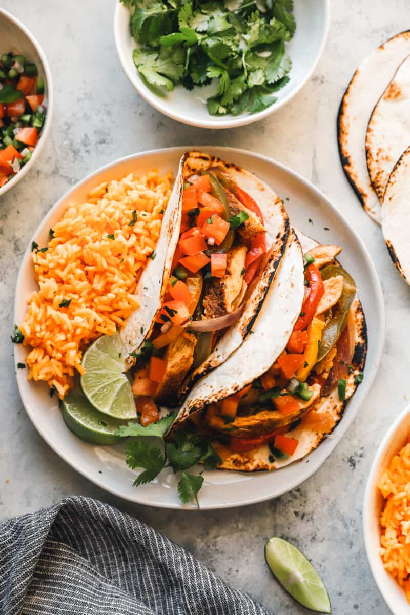 chicken fajitas on a white plate with rice