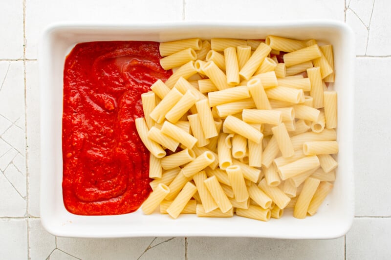 noodles and sauce in a white baking dish