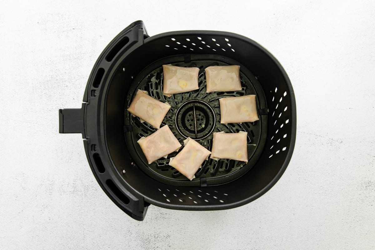 Pizza rolls in an air fryer before cooking.