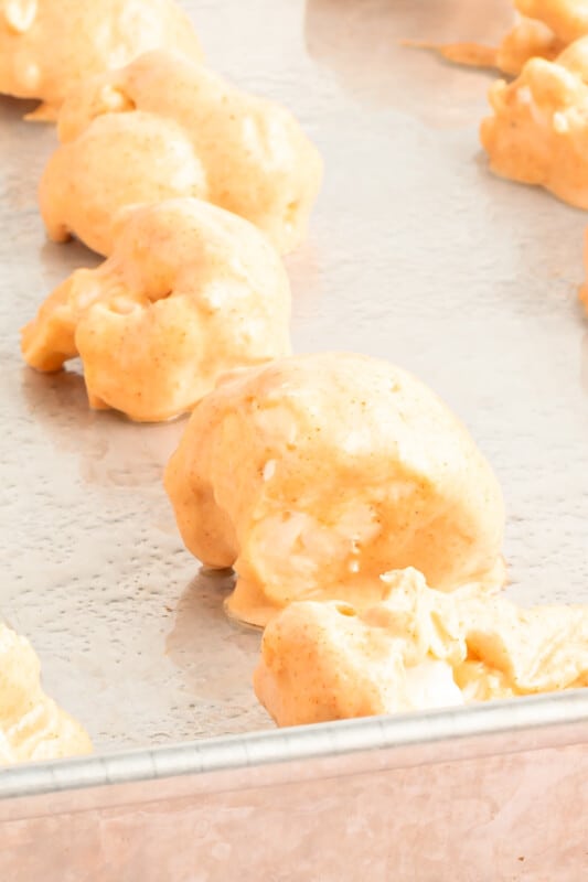 buffalo cauliflower wings on a baking sheet before baking