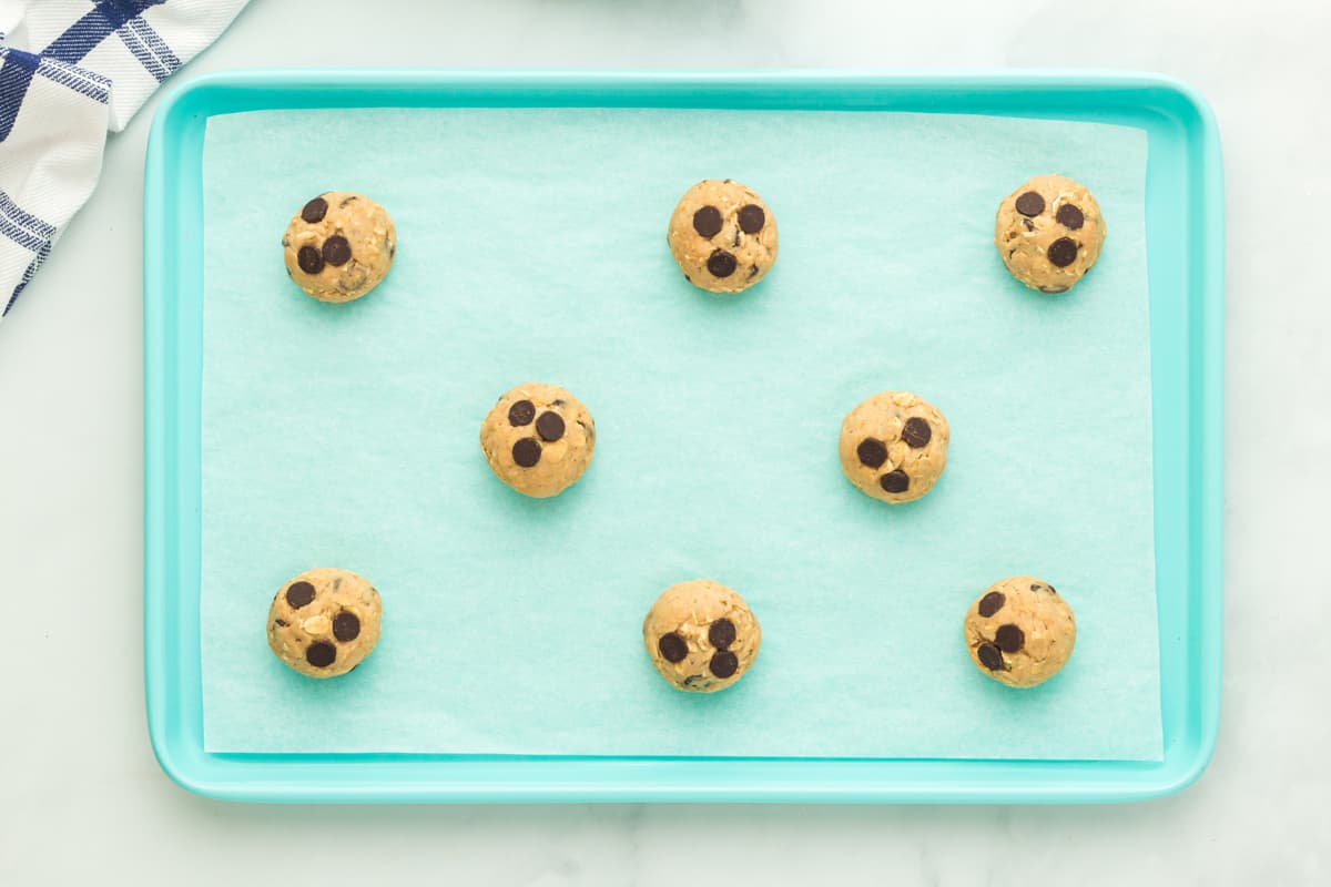 chocolate chip cookies on a parchment paper lined baking sheet before baking.