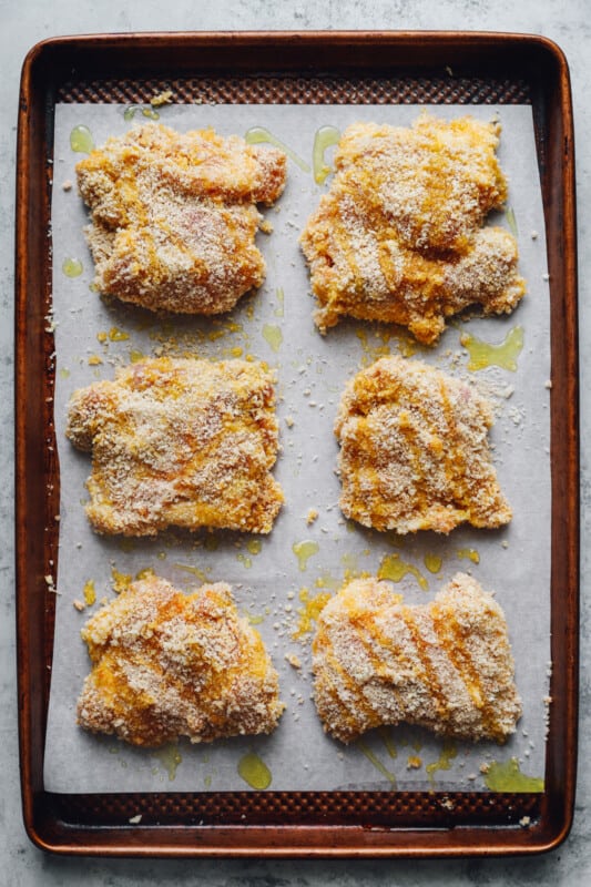 chicken thighs on a parchment paper lined baking sheet before baking