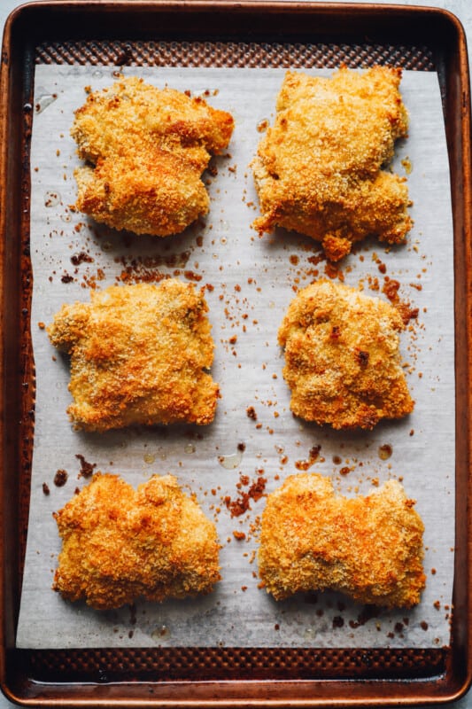 chicken thighs on a parchment paper lined baking sheet after baking