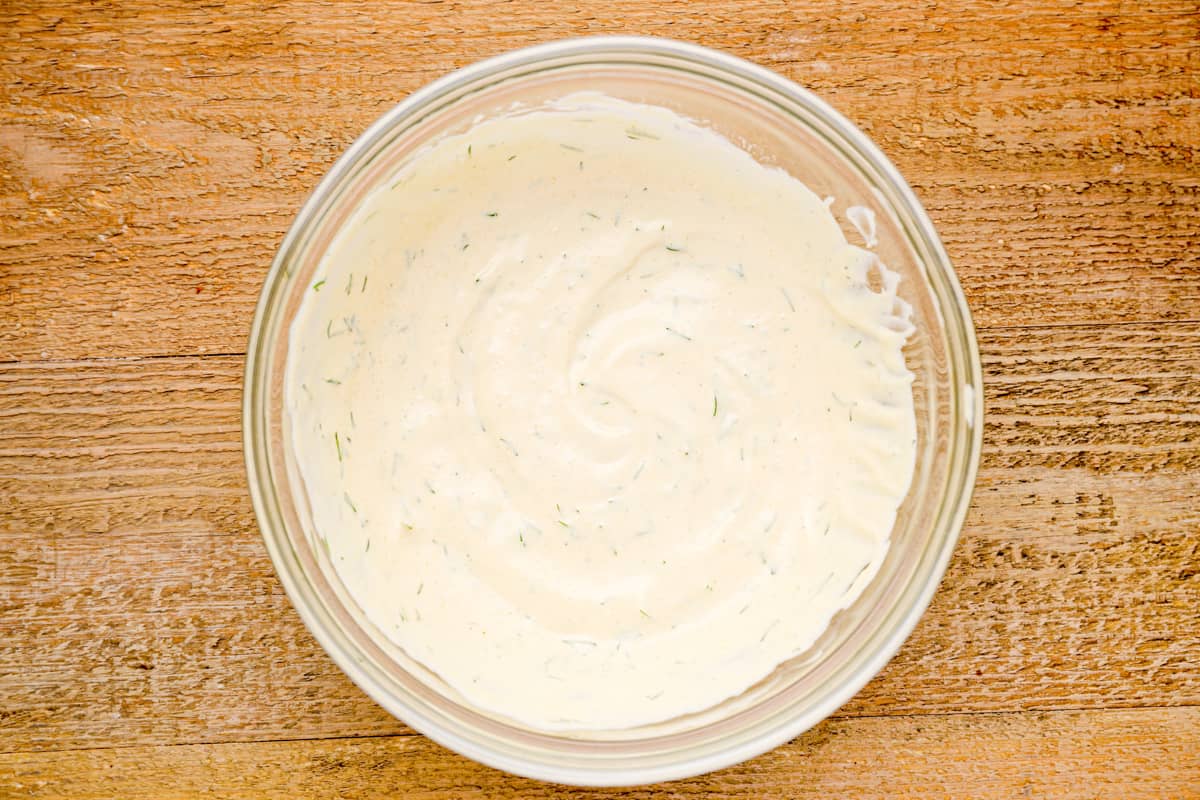 mayonnaise with herbs in a glass bowl.