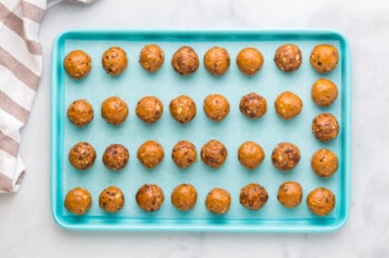 chocolate peanut butter protein balls on a parchment lined baking sheet