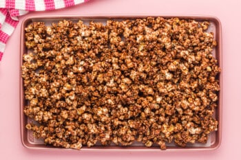 chocolate popcorn on a parchment paper lined baking sheet
