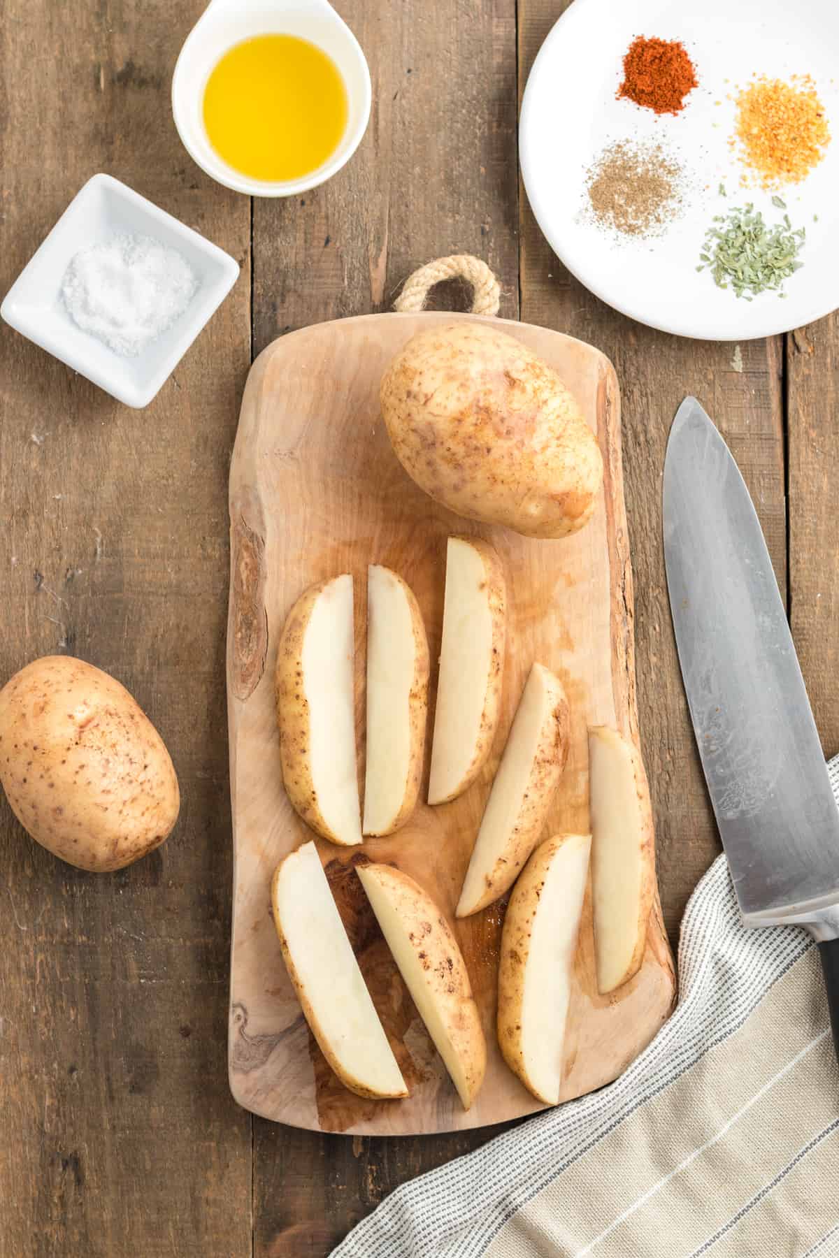 sliced potato wedges on a wood cutting board