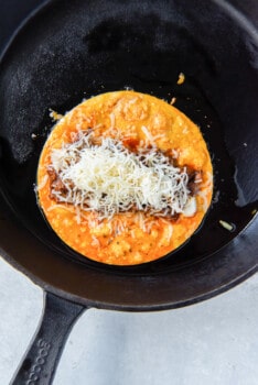 tortilla with meat and cheese in a skillet