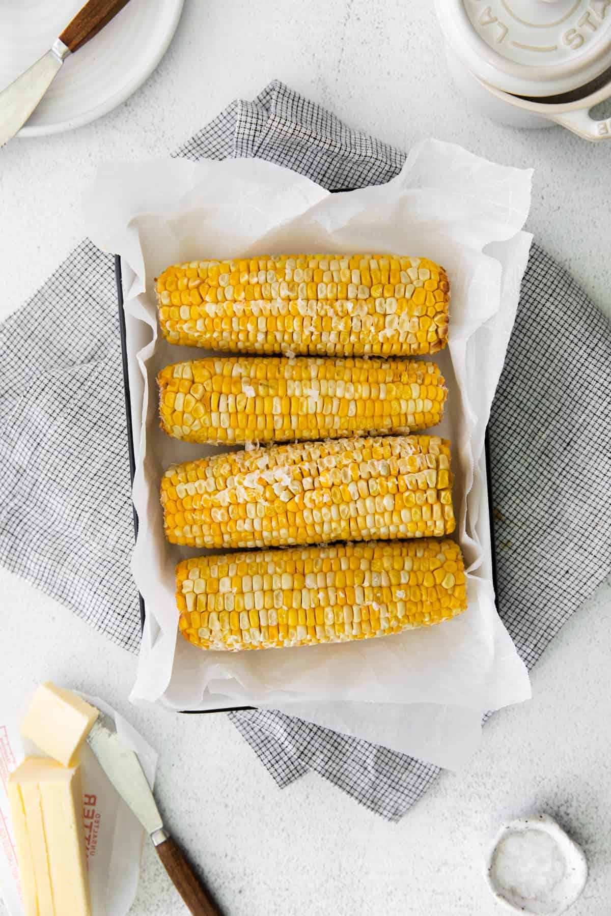 overhead image of 4 ears of corn on the cob on a serving platter