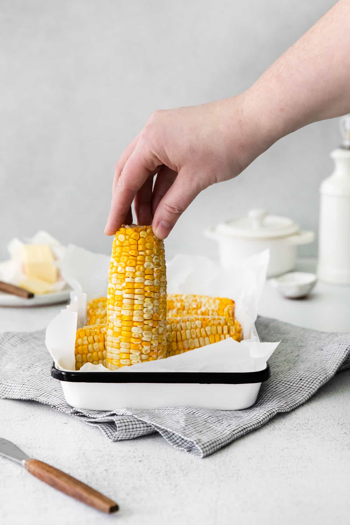 hand grabbing an ear of corn on the cob