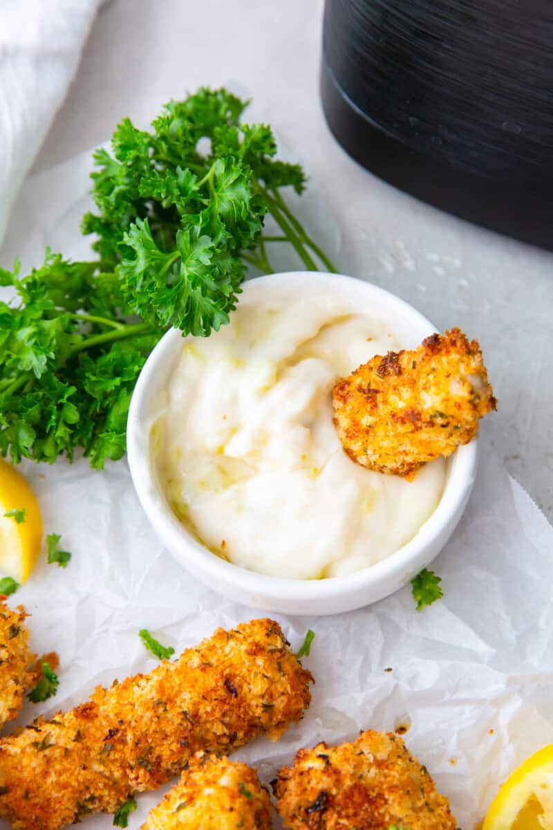 fish stick in a bowl of dipping sauce