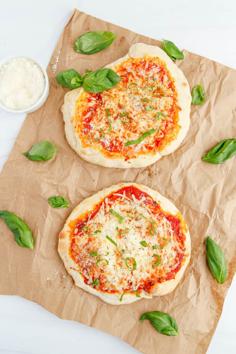 overhead image of 2 small cheese pizzas on parchment paper