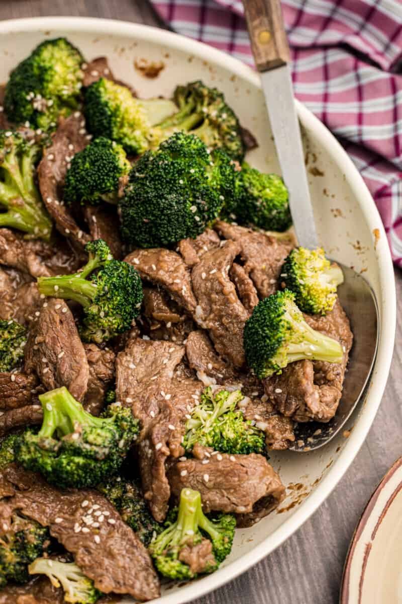 serving spoon in a bowl of beef and broccoli