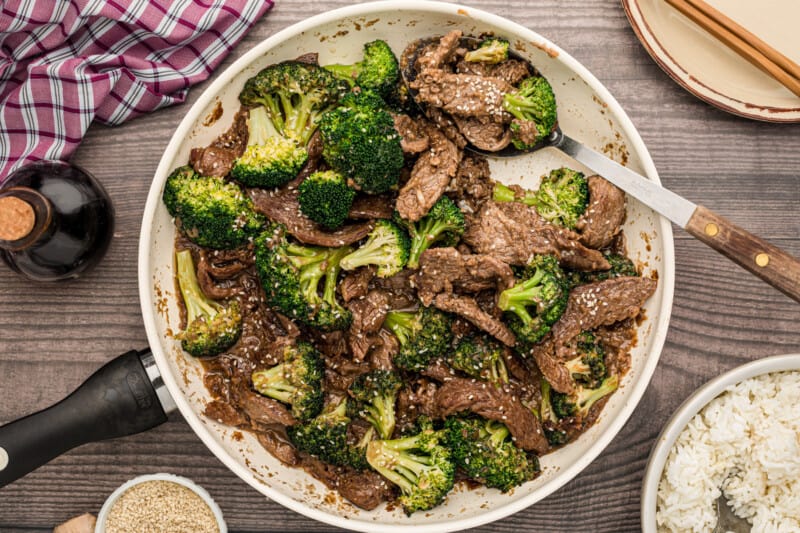 beef and broccoli in a skillet with a serving spoon
