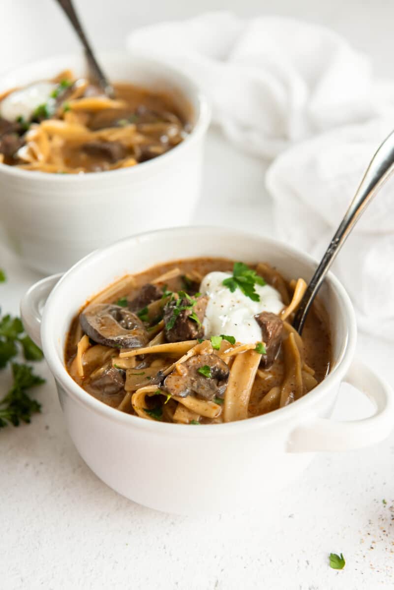 2 bowls of beef stroganoff soup with spoons