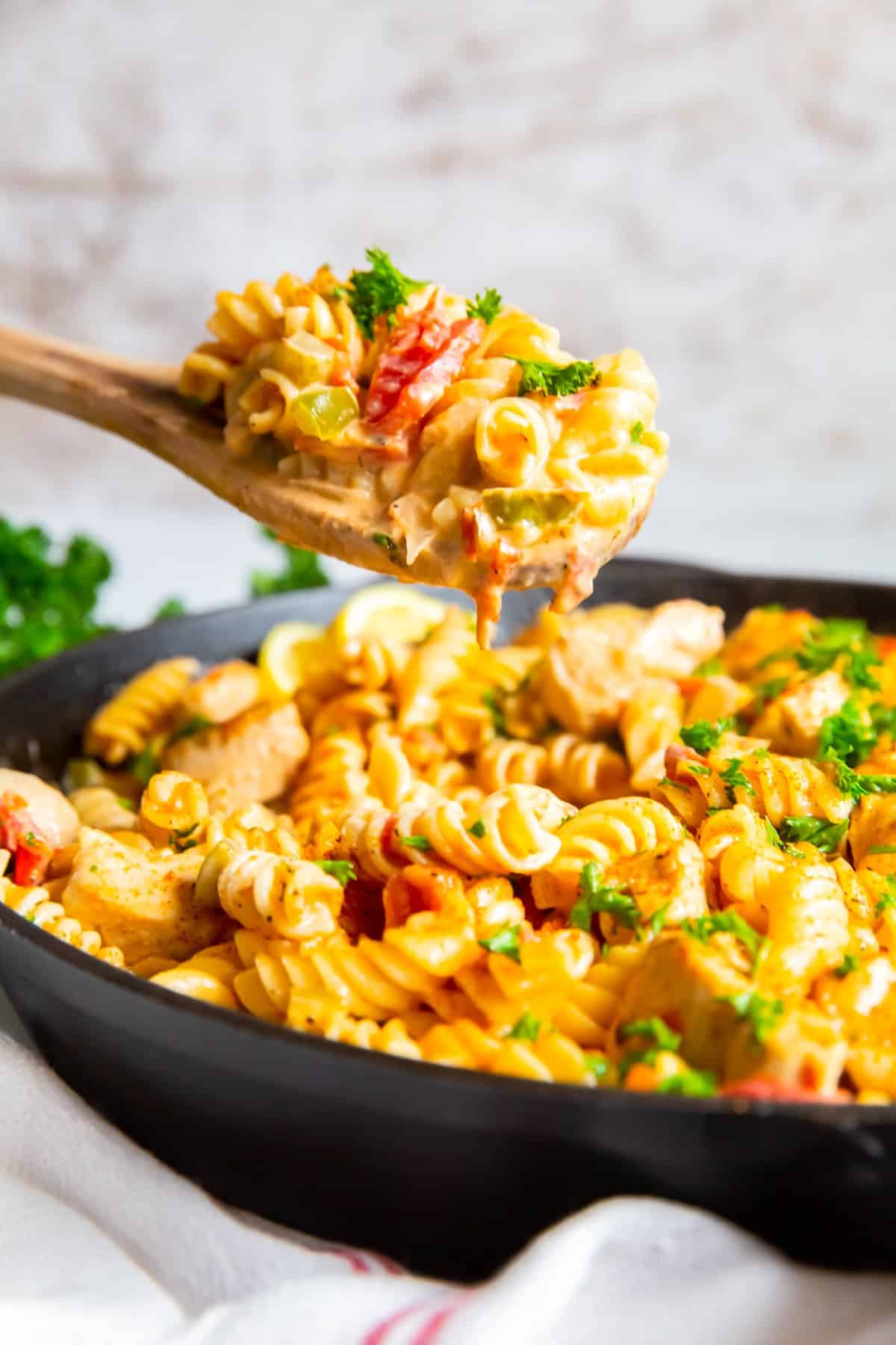 wood spoon with a serving of cajun chicken pasta