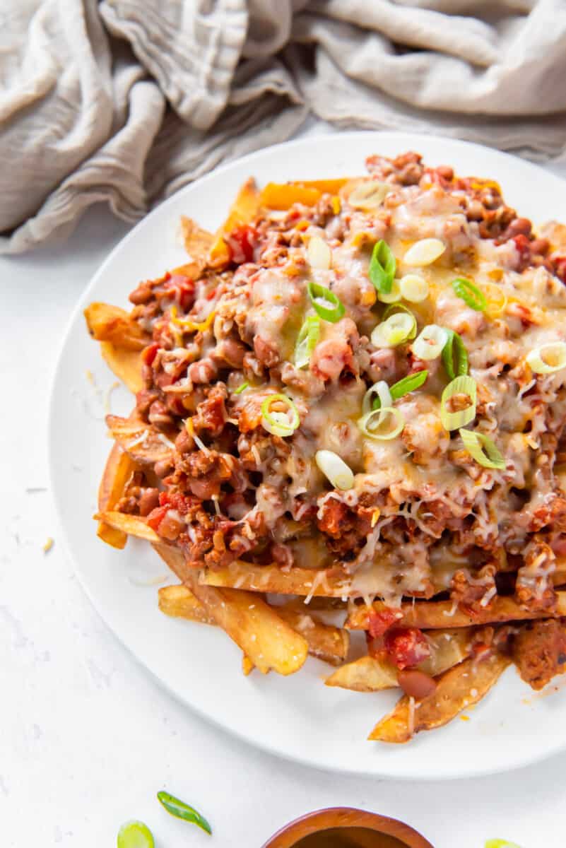 chili cheese fries on a white plate