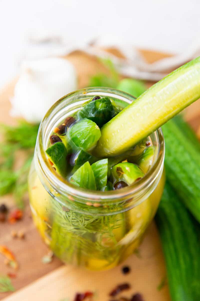 pickles in a jar with one being pulled out