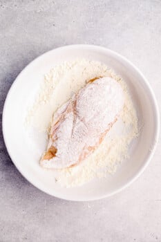 chicken breast coated in flour on a white plate