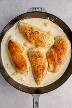 chicken breasts in creamy garlic sauce in a skillet