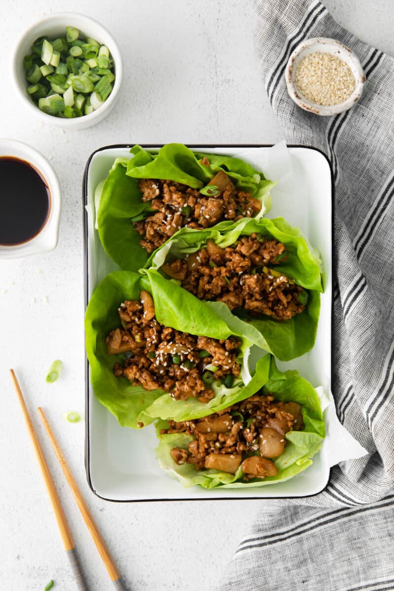 overhead view of pf changs lettuce wraps on a white tray with chopsticks.