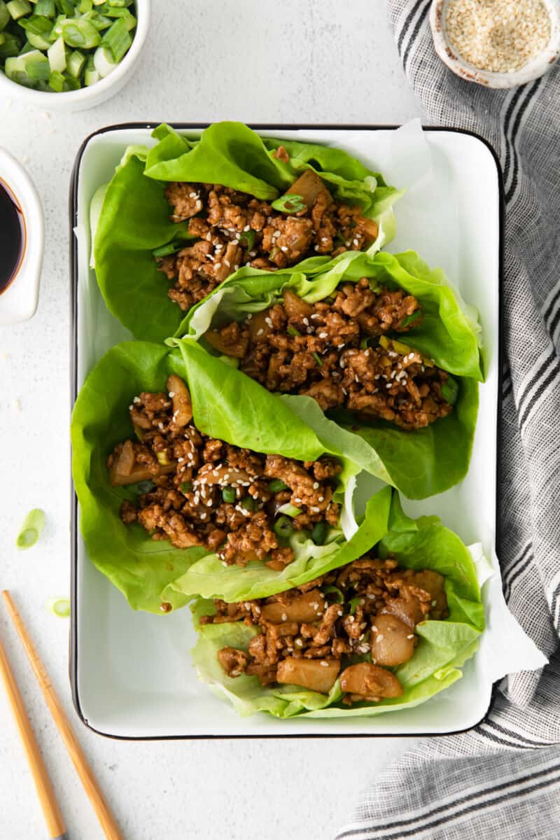 close up of pf changs lettuce wraps on a white tray with chopsticks.