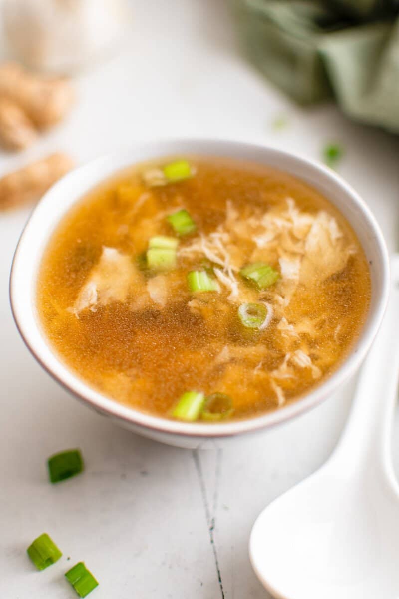 egg drop soup in a white bowl with a white spoon.