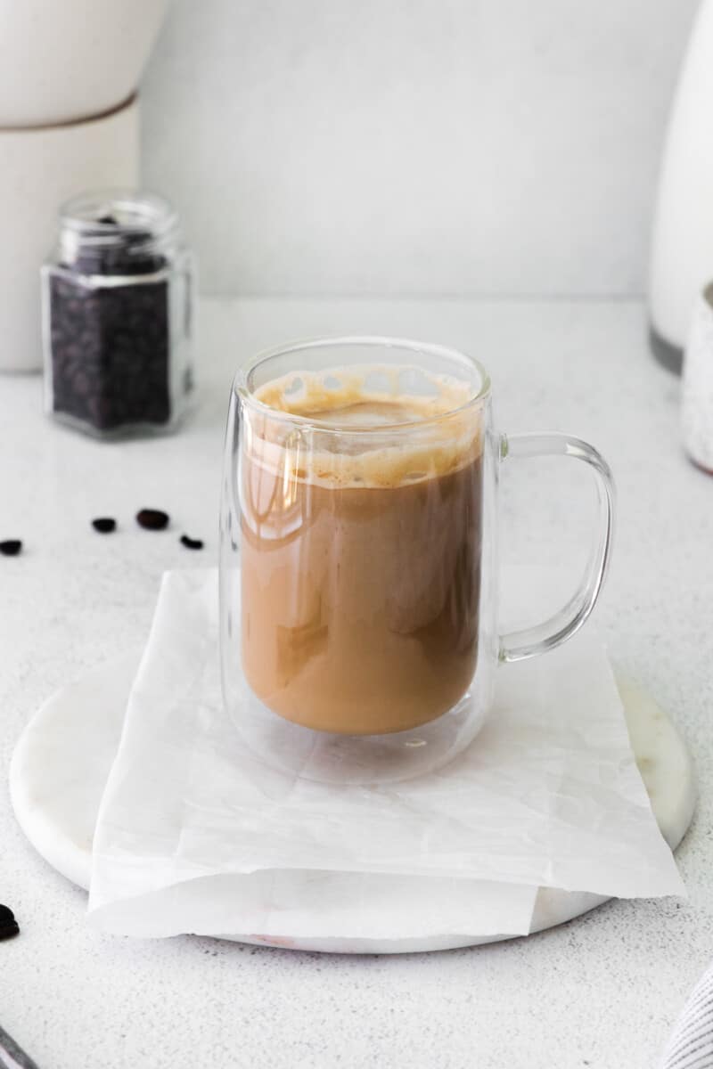 flat white drink in a glass mug