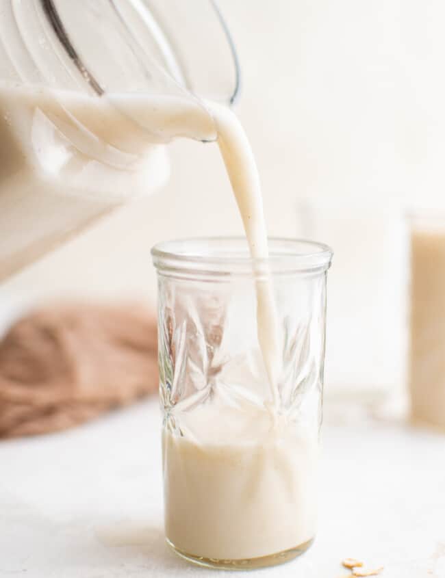 pouring oat milk into a glass