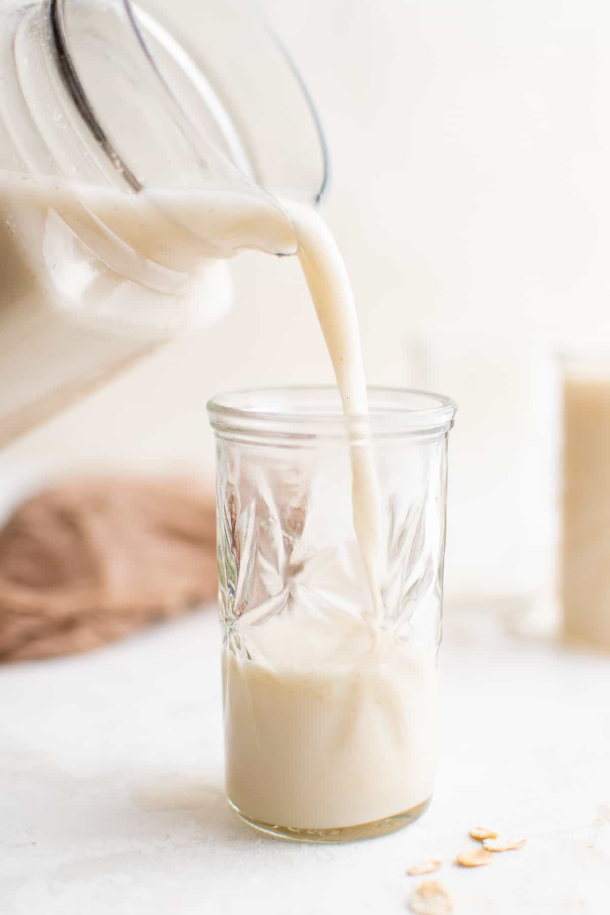 pouring oat milk into a glass