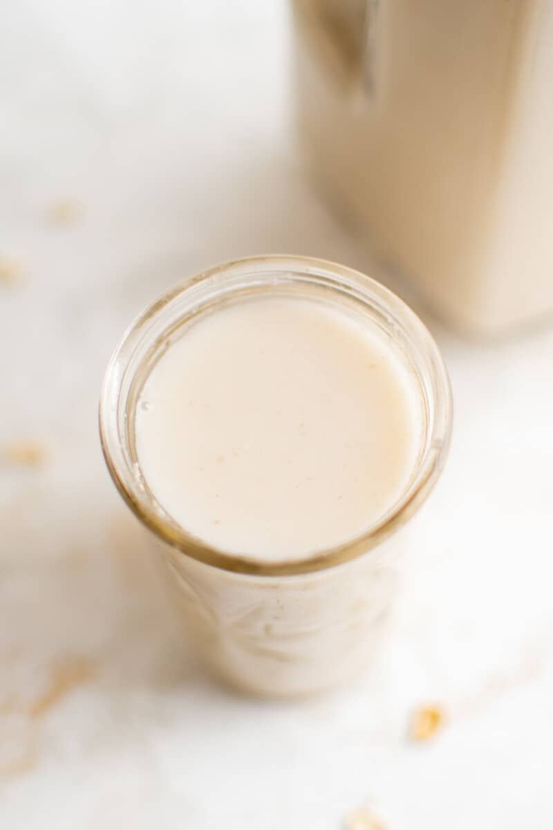 A glass full of homemade oat milk from an overhead angle.