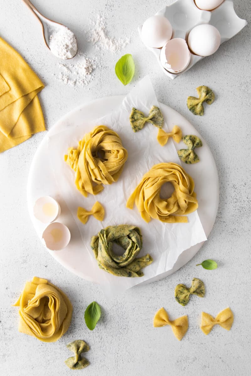 overhead view of 3 nests of homemade pasta on a round marble server.