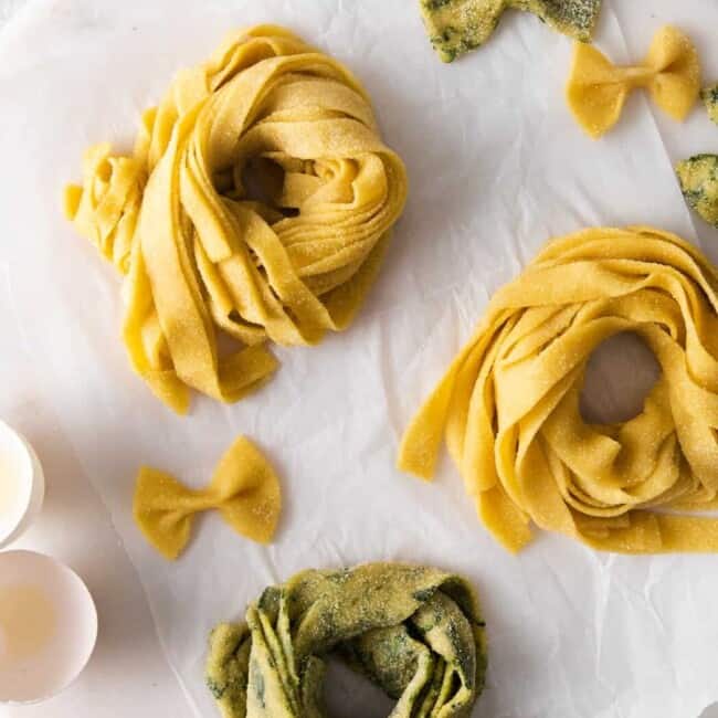 overhead view of 3 nests of homemade pasta on a round marble server.