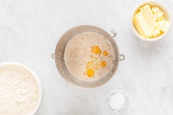 A bakery-style bowl of flour, eggs and butter on a marble table, perfect for making cinnamon rolls.