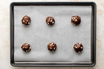 6 chocolate cake mix cookie dough balls on a baking sheet.