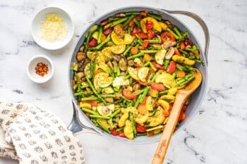 satueed vegetables in a saute pan after cooking with a wood spoon