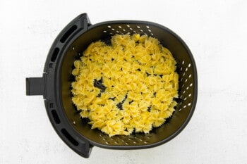 cooked pasta in the basket of an air fryer.