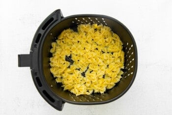 cooked pasta in the basket of an air fryer.