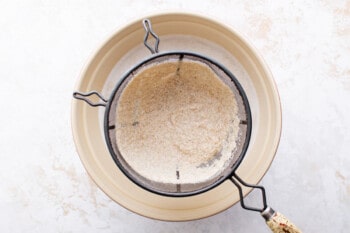 oat milk strained through a wire sieve over a bowl