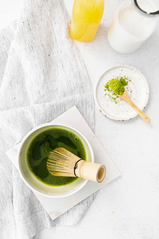 matcha powder whisked with water in a white bowl.
