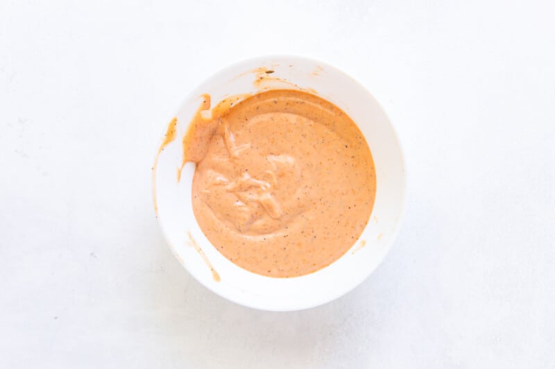 overhead view of mixed raising cane's sauce in a white bowl.