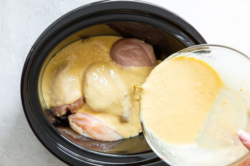 gravy poured over chicken in a crockpot.