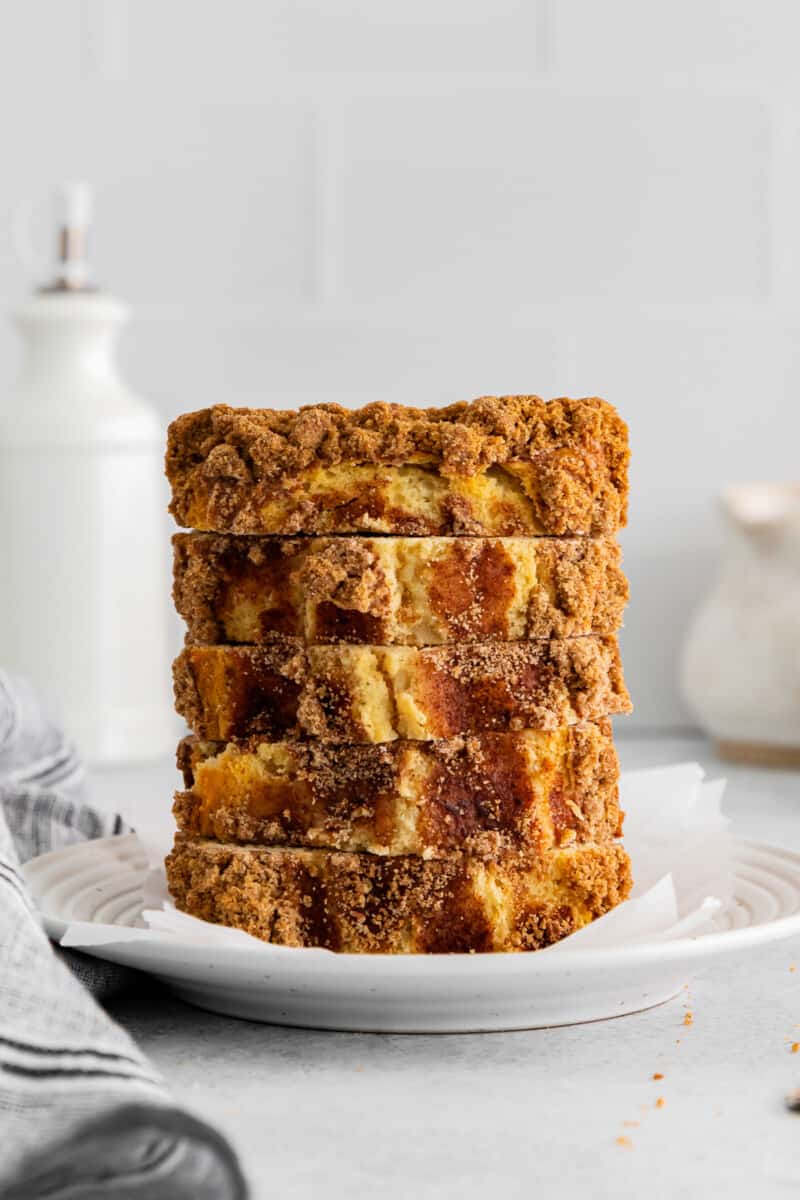 5 slices of cinnamon roll bread stacked on a white plate.