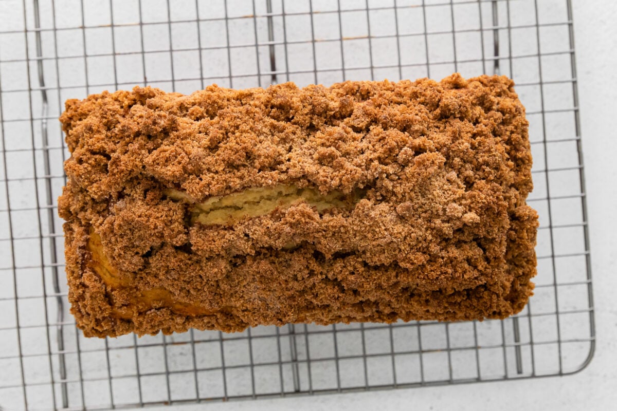 overhead view of cinnamon roll bread on a wire rack.