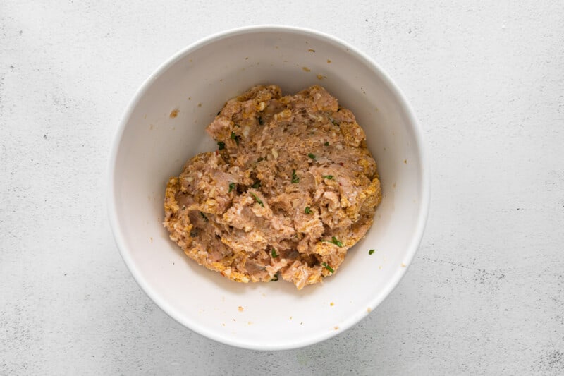 meatball mixture for chicken parmesan meatballs in a white bowl.