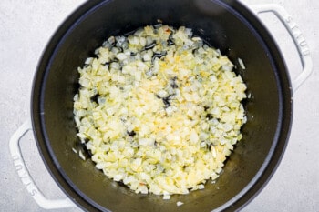 onions and garlic in a white dutch oven.