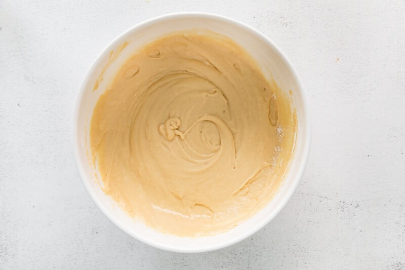 overhead view of cinnamon roll bread batter in a white bowl.