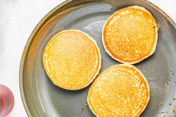 3 gluten free pancakes in a skillet.