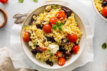 overhead view of mediterranean orzo salad in a white bowl.