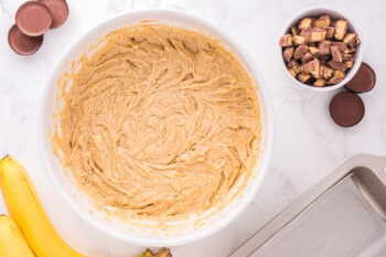 reeses peanut butter cup banana bread batter in a white bowl.